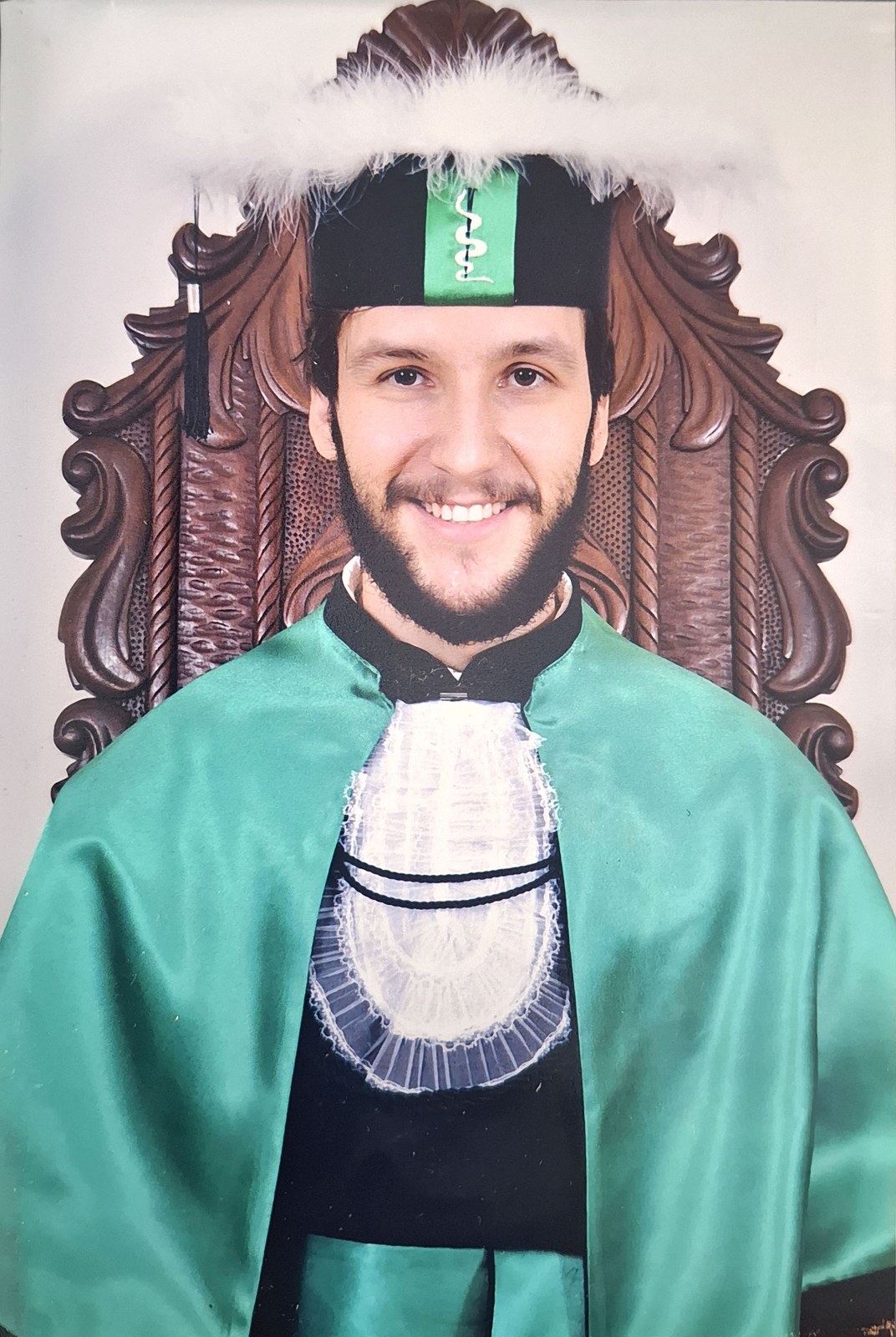 Iago Caires vestindo beca e capelo na sua formatura em Medicina.